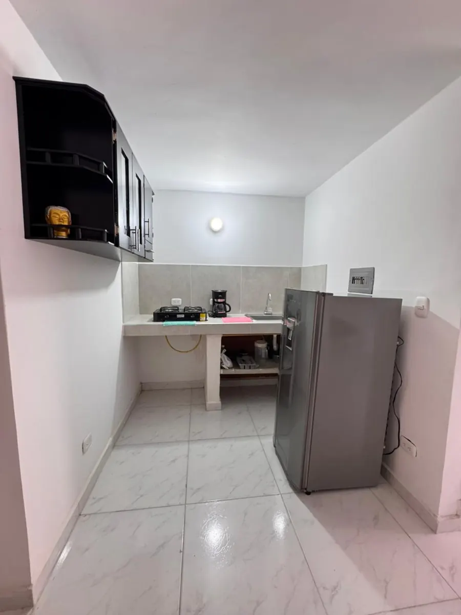 Cocina con estufa, cafetera y nevera
