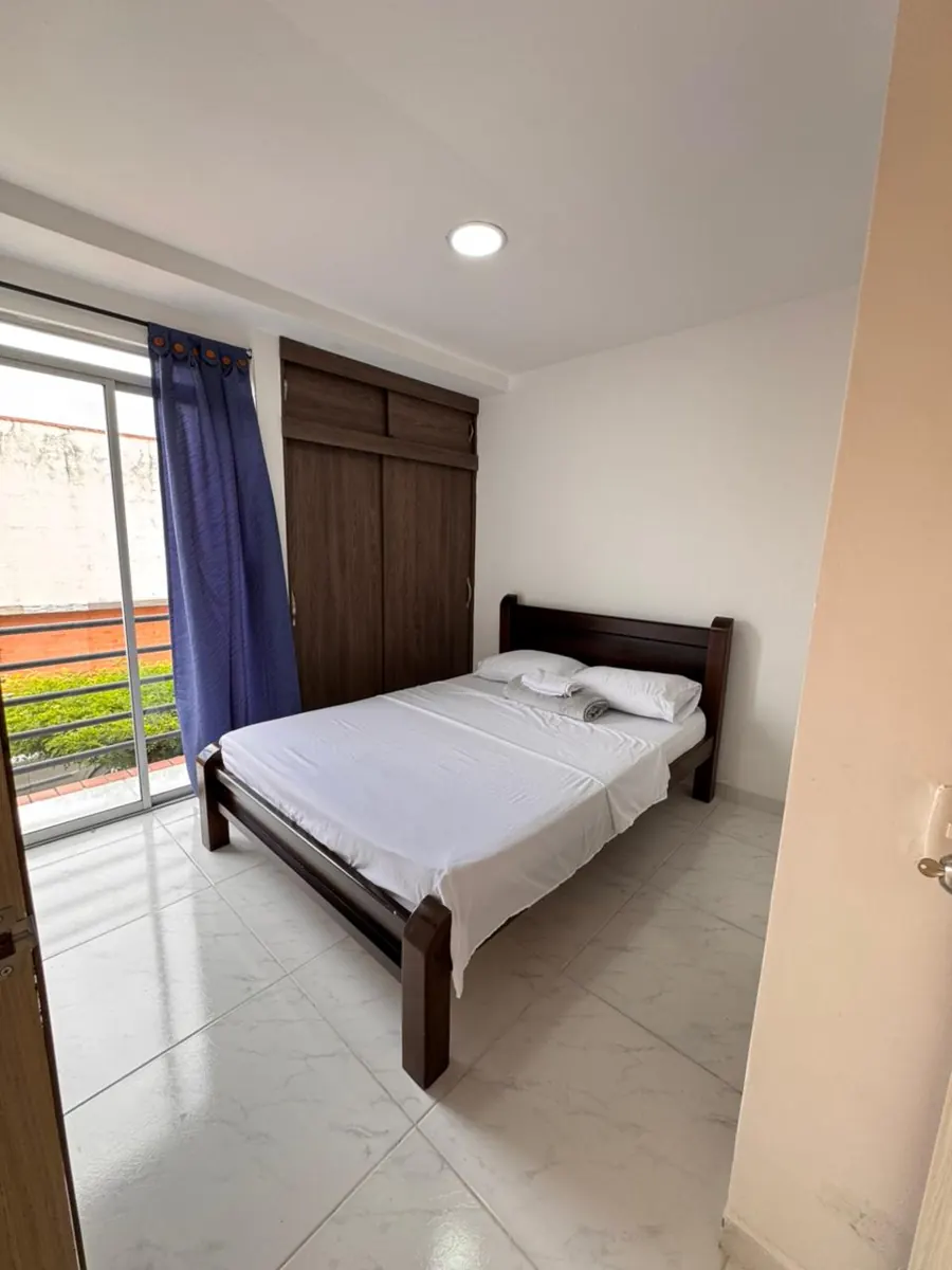 Habitación doble con cama de madera y balcón